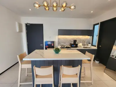 a kitchen with a large island with chairs around it at Urban Suite - George Town in Jelutong