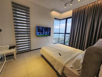 a bedroom with a bed and a tv on the wall at Urban Suite - George Town in Jelutong