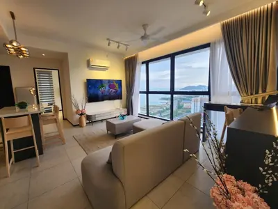 a living room with a couch and a large window at Urban Suite - George Town in Jelutong