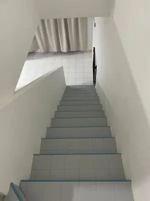 a staircase in a building with a person walking down it at SunShine HomeStay in Bukit Mertajam