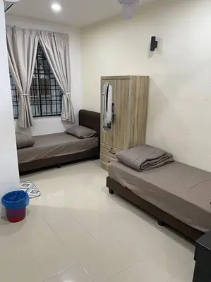 a living room with two beds and a tv at SunShine HomeStay in Bukit Mertajam