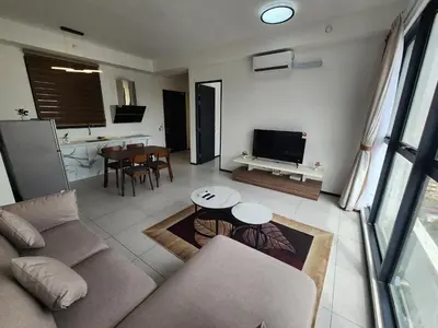 a living room with a couch and a tv and a table at Urban Suites - Penang in Jelutong