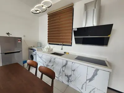 a kitchen with a sink and a counter with a table at Urban Suites - Penang in Jelutong