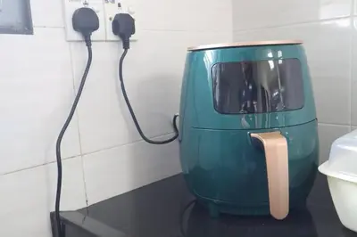 a green appliance is plugged into a wall next to a toilet at Green Space Homestay Cozy Family(8-12pax) in Ipoh