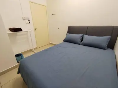 a bed with blue pillows in a room at Nana's Sitiawan Home Stay, Victoria cottage in Sitiawan