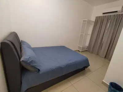 a bedroom with a bed with blue sheets and a window at Nana's Sitiawan Home Stay, Victoria cottage in Sitiawan
