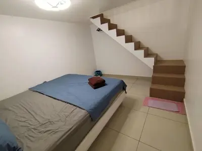 a bedroom with a bed and a staircase at Nana's Sitiawan Home Stay, Victoria cottage in Sitiawan