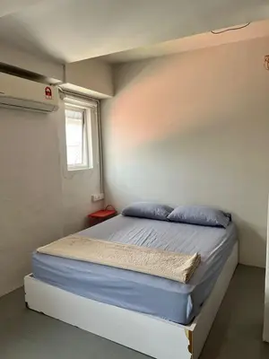 a bedroom with a bed with blue pillows and a window at Sunshine House in George Town