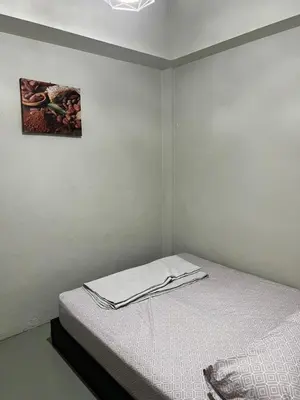 a white room with a bed with a picture on the wall at Sunshine House in George Town