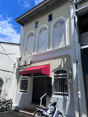 a scooter parked in front of a white house at Sunshine House in George Town