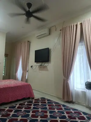 a bedroom with a bed and a flat screen tv at Cp homestay in Batu Kurau