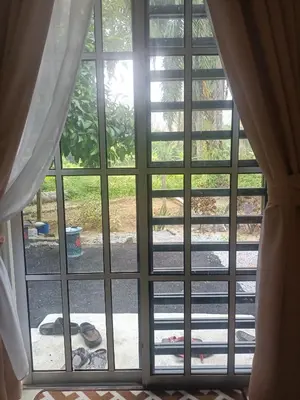 a window with a view of a yard at Cp homestay in Batu Kurau