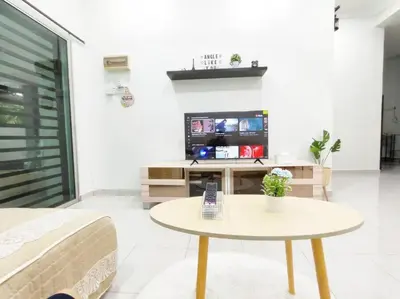 a living room with a table and a tv at Bidor Family Choice 3 Bedrooms WIFI in Bidur