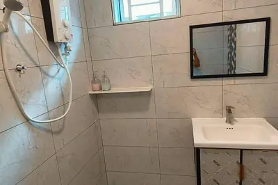 a bathroom with a sink and a shower and a mirror at Wi-Fi 100MB free Ipoh Homefeel 4 rooms Tatami S48 in Ipoh