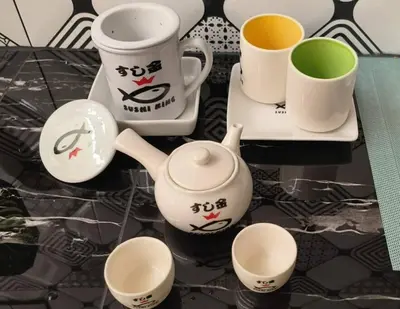 a group of cups and saucers on a table at Wi-Fi 100MB free Ipoh Homefeel 4 rooms Tatami S48 in Ipoh