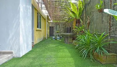 a courtyard with green grass and plants in a building at GOPENG INN in Gopeng