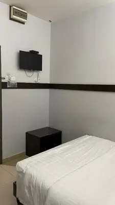 a bedroom with a bed and a tv on the wall at GOPENG INN in Gopeng