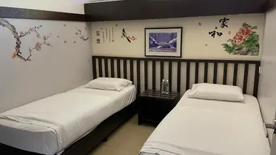 two beds in a small room at GOPENG INN in Gopeng