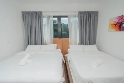 two twin beds in a room with a window at Ipoh Tambun Sunway Onsen Suite 3R2B Maya in Tambun