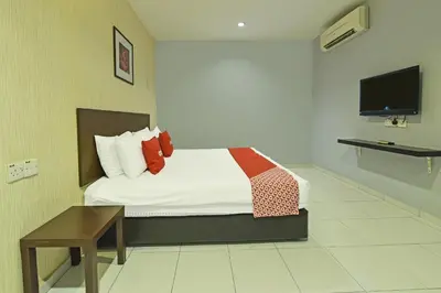 a hotel room with a bed and a tv at Hotel O M Three Hotel in Kampong Batu Tiga