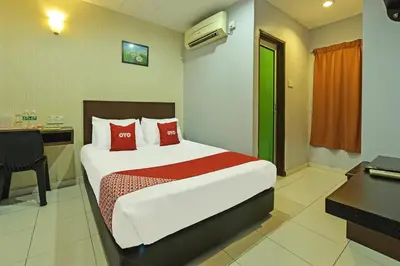 a hotel room with a bed and a desk and a computer at Hotel O M Three Hotel in Kampong Batu Tiga