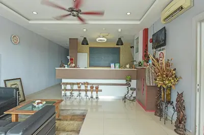 a living room with a ceiling fan and a table at Hotel O M Three Hotel in Kampong Batu Tiga