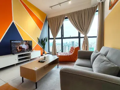 a living room with a couch and a tv at Cozy Minimalist Suite at Urban Suites Georgetown by SuperStay in Jelutong