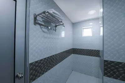 a bathroom with a shower with a glass door at Capital O 90543 Sp Star Hotel in Sungai Petani