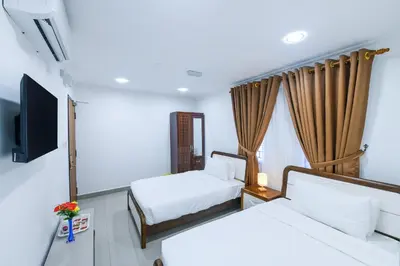 a hotel room with two beds and a flat screen tv at Capital O 90543 Sp Star Hotel in Sungai Petani