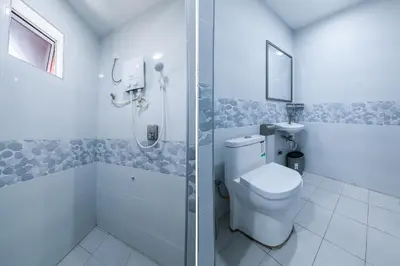 a white bathroom with a shower and a toilet at Capital O 90543 Sp Star Hotel in Sungai Petani