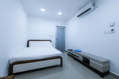 a white room with a bed and a desk at Capital O 90543 Sp Star Hotel in Sungai Petani