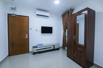 a room with a wooden door and a television at Capital O 90543 Sp Star Hotel in Sungai Petani