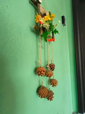 a hanging decoration with pine cones and flowers on a wall at (WI-FI) Ipoh Holiday Big House double storey DR8 in Ipoh
