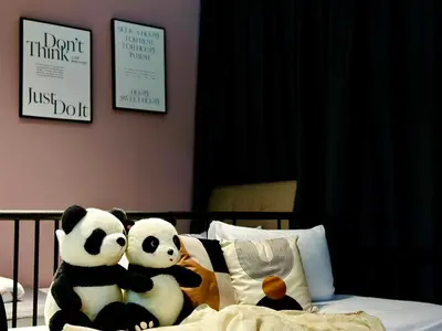 two pandas sitting on top of a bed at New Comfy Urban Suite Homestay at Georgetown for family by Urban Staycations LOD COSY in Jelutong