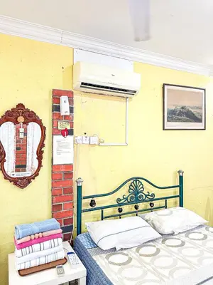 a bedroom with a bed and a table in a room at Dusun Indah Cottage 1 in Bayan Lepas