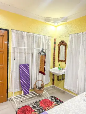 a bathroom with a bed and a sink and a mirror at Dusun Indah Cottage 1 in Bayan Lepas