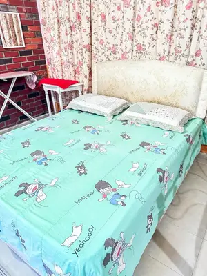 a bed with a blue blanket with cartoon animals on it at Dusun Indah Cottage 2 in Bayan Lepas