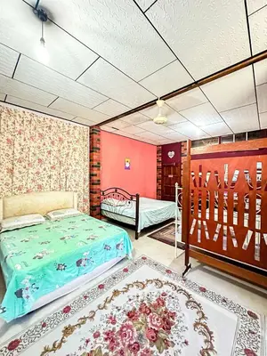 a bedroom with two beds and a rug at Dusun Indah Cottage 2 in Bayan Lepas