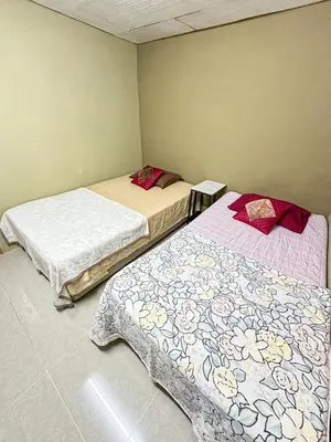 two beds in a small room with at Dusun Indah Cottage 3 in Bayan Lepas