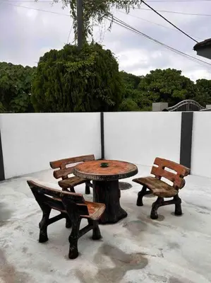 a table and two chairs sitting next to a tree stump at Juzt Homestay Kpg Boyan in Taiping