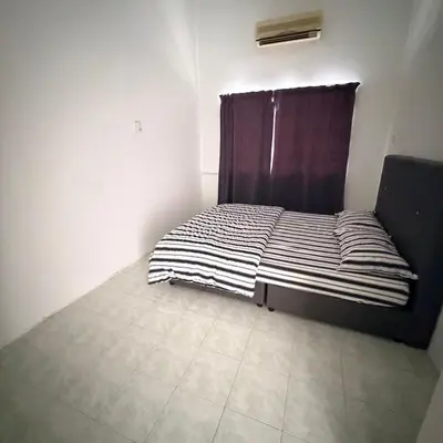 a bed in a room with a black and white blanket at Juzt Homestay Kpg Boyan in Taiping