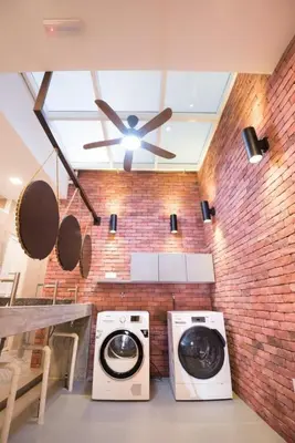 a washer and dryer in a room with a brick wall at Sogor Female Dormitory in George Town