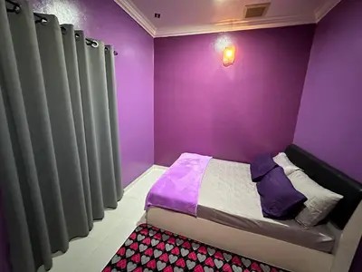 a purple room with a bed and curtains at ARY&ZZ Homestay for islam guests in Tanjung Karang