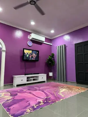 a living room with purple walls and a tv at ARY&ZZ Homestay for islam guests in Tanjung Karang