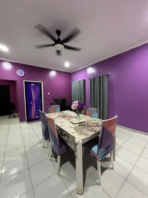 a dining room with a table and purple walls at ARY&ZZ Homestay for islam guests in Tanjung Karang