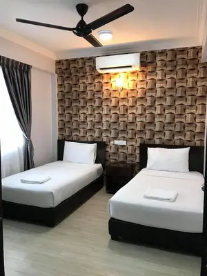 a bedroom with two beds and a ceiling fan at Zaque's Hotel in Sungai Petani