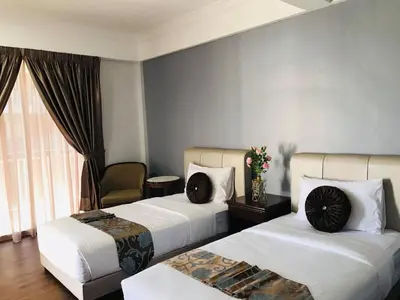 a hotel room with two beds and a window at Zaque's Hotel in Sungai Petani