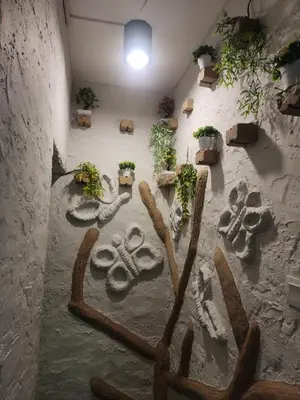 a wall with a painting on it with plants at Clock Inn Backpackers Hostel in Tanah Rata