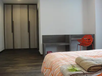 a bedroom with a bed and a desk and a chair at Batu Ferringhi - Shamrock Beach Villas, Penang in Batu Ferringhi