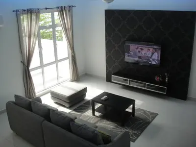 a living room with a couch and a tv at Batu Ferringhi - Shamrock Beach Villas, Penang in Batu Ferringhi